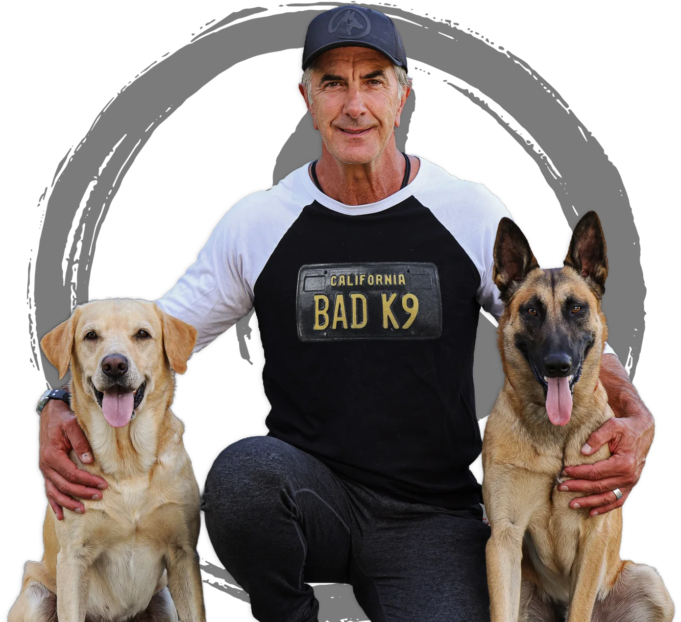 Robert Cabral kneeling with a Labrador and a Malinois